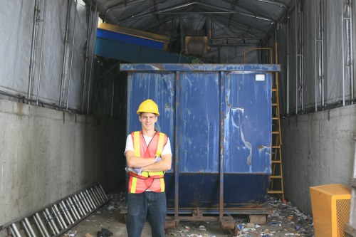 Supervisor reviewing a risk assessment on site with waste containers in the background